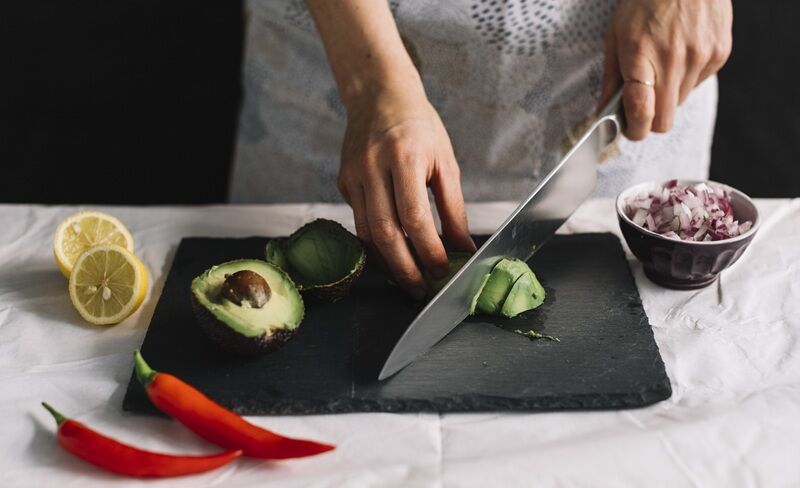 A Complete Guide to Choosing the Right Professional Knife Sharpener A person cutting vegetables with knife
