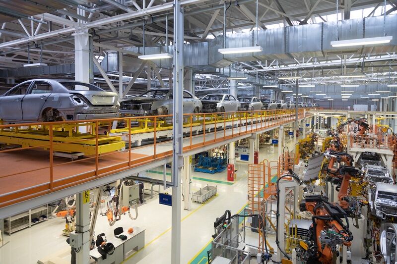 How to Reduce Maintenance Costs in High-Volume Manufacturing Plants body of car on conveyor Modern Assembly of cars at plant. automated build process of car body.